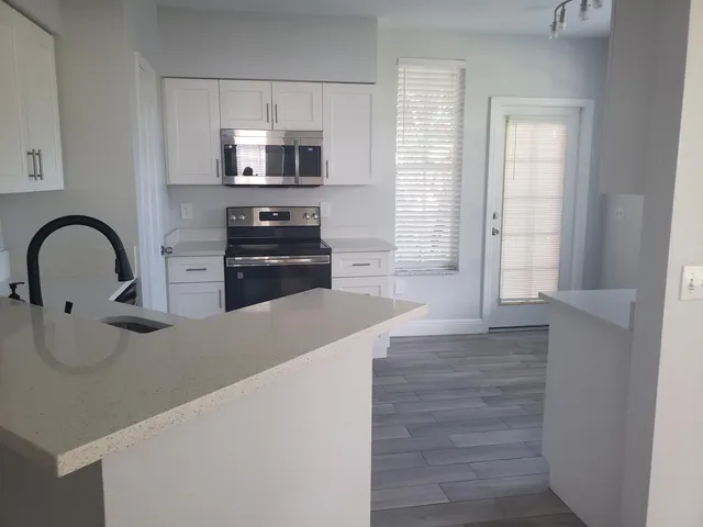 a kitchen with granite countertop a stove and a microwave