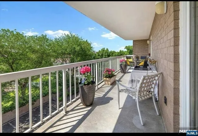 a view of two chairs and table in a balcony
