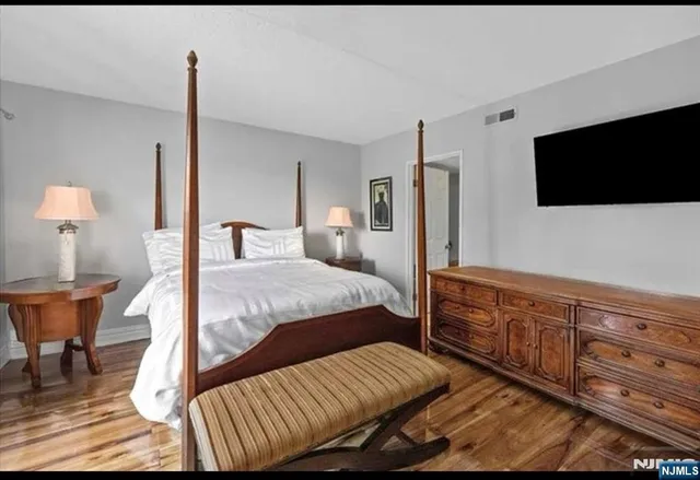 a bedroom with a bed window and a flat screen tv