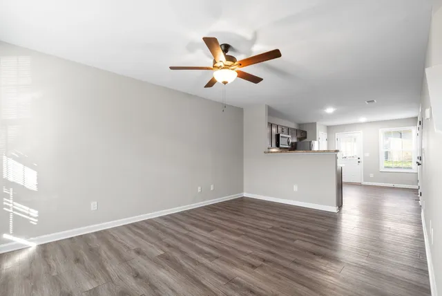 a view of a kitchen with wooden floor and a ceiling fan