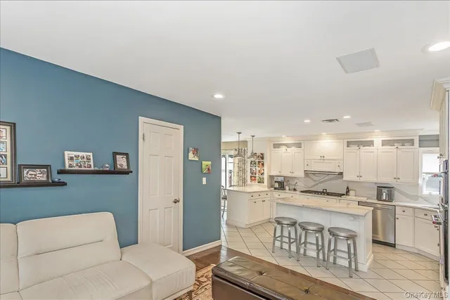 a open kitchen with white cabinets and stainless steel appliances
