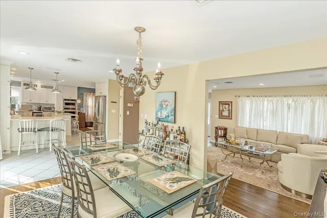 a view of a dining room with furniture a chandelier and wooden floor