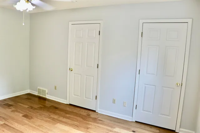 an empty room with wooden floor and a window