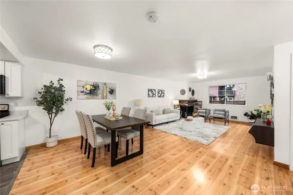 a living room with furniture a wooden floor and a potted plant