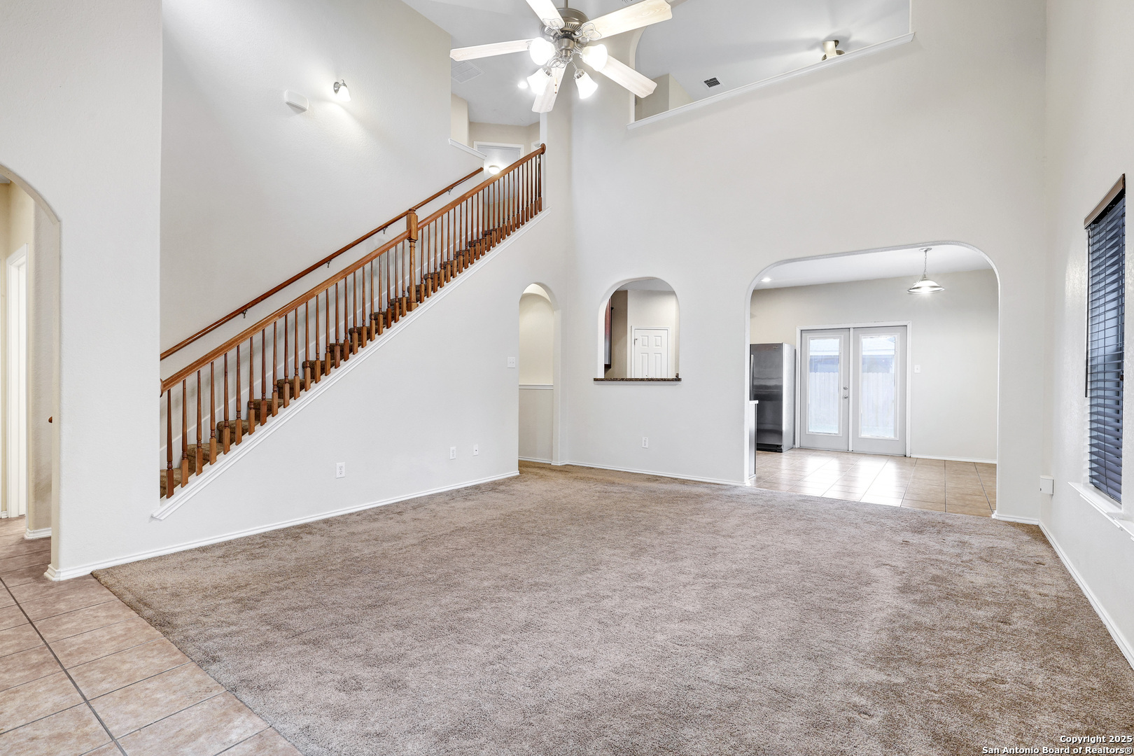 10410 Weser Lane Helotes, TX 78023 - Photo 12 of 22 a view of an empty room with chandelier fan and wooden floor