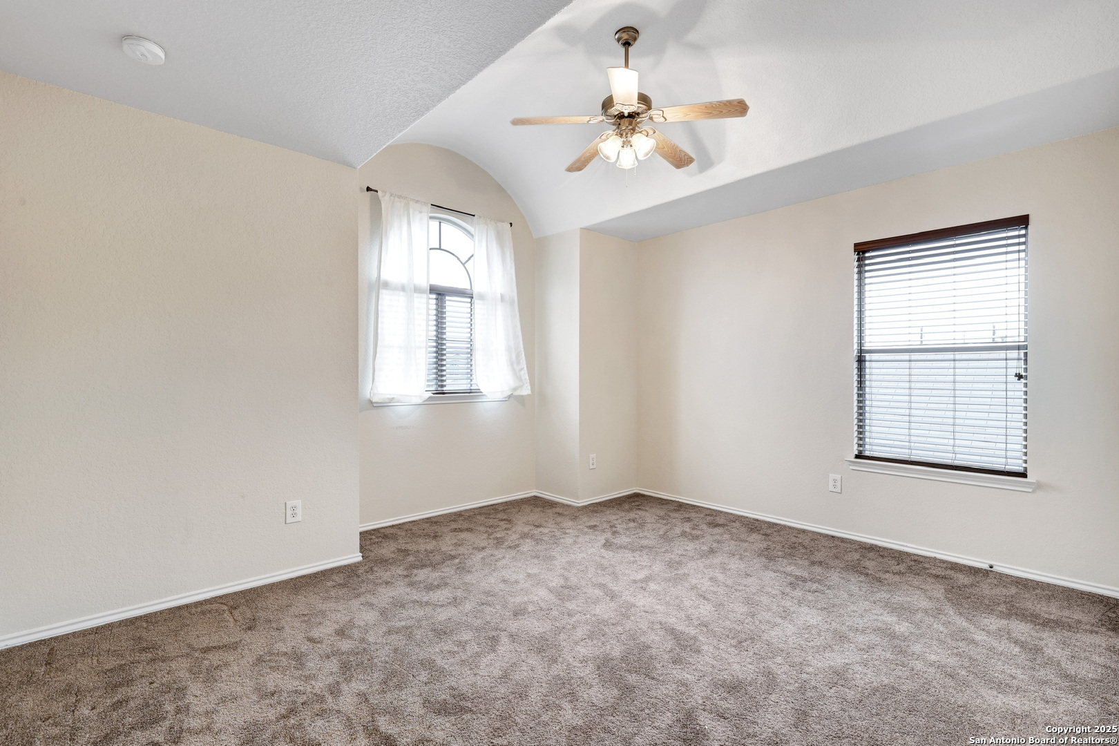 10410 Weser Lane Helotes, TX 78023 - Photo 14 of 22 an empty room with windows and chandelier fan
