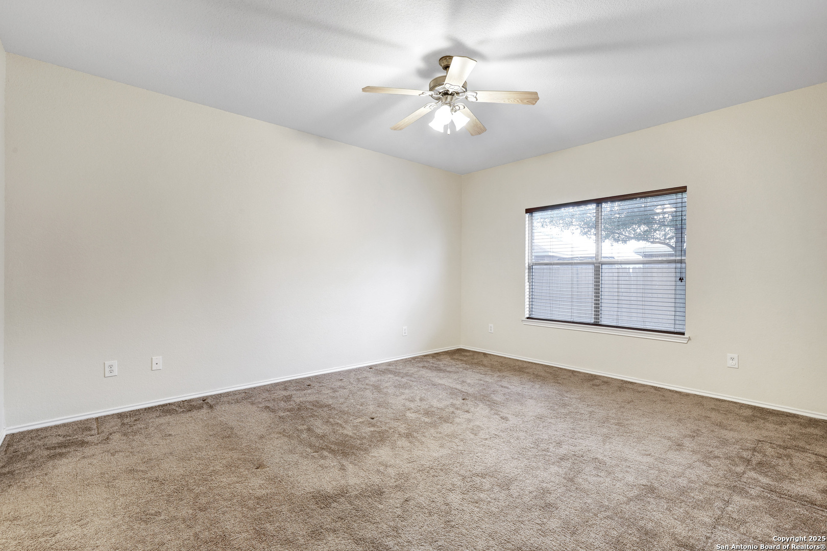 10410 Weser Lane Helotes, TX 78023 - Photo 5 of 22 an empty room with windows and chandelier fan