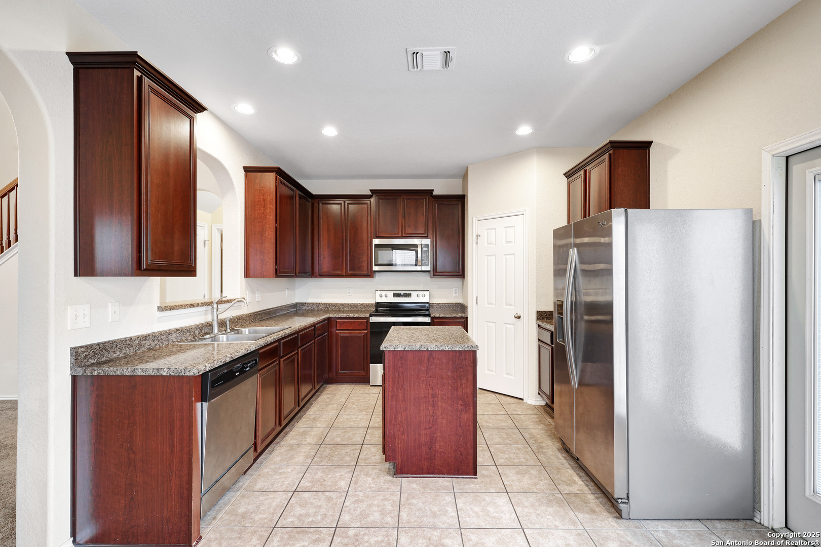 10410 Weser Lane Helotes, TX 78023 - Photo 7 of 22 a large kitchen with stainless steel appliances granite countertop a stove a refrigerator and a sink