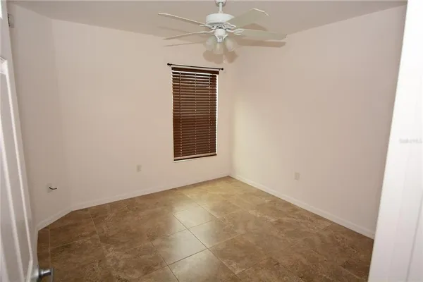 an empty room with a window and a fan