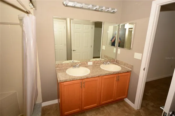 a bathroom with a granite countertop sink a mirror and a shower