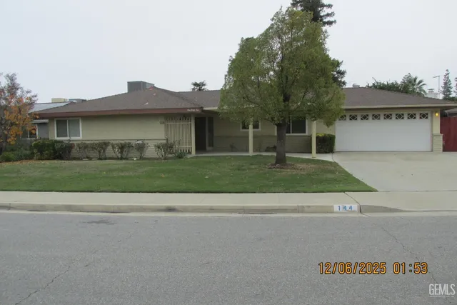 a view of a house with a yard and potted plants