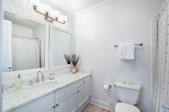 a bathroom with a granite countertop toilet sink and mirror