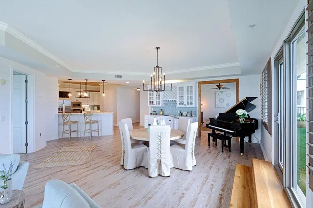 a dining room with furniture a chandelier and wooden floor