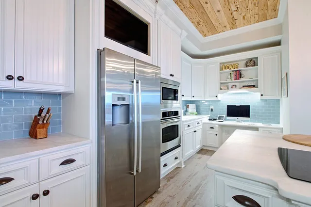 a kitchen with a refrigerator and white cabinets