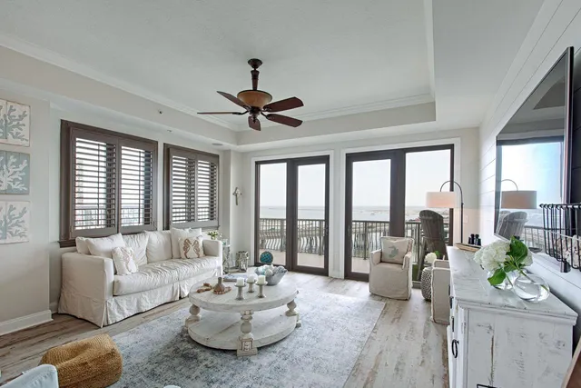 a living room with furniture and floor to ceiling windows