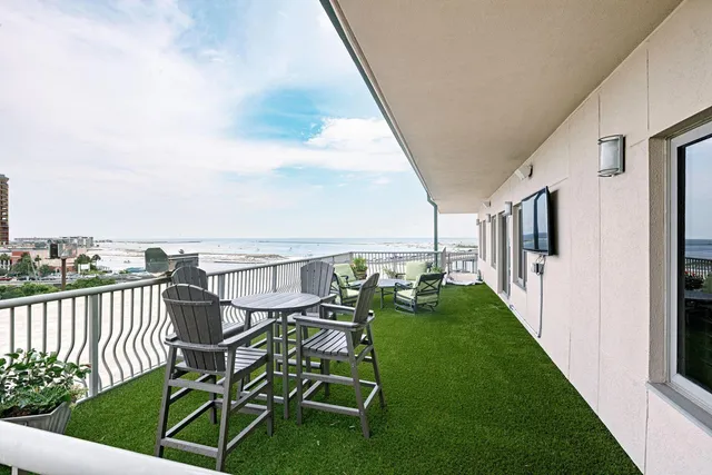a view of a balcony with chairs and wooden fence