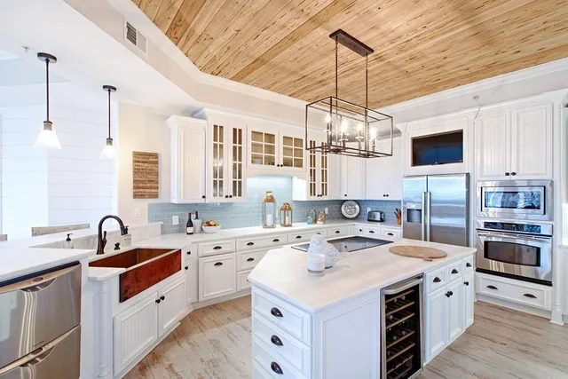a kitchen that has a lot of cabinets in it and wooden floors
