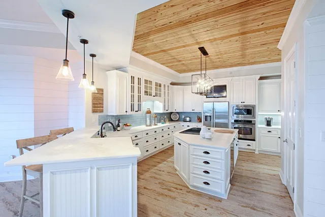 a kitchen with a sink a counter space appliances and cabinets