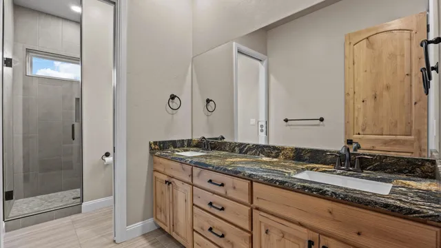 a bathroom with a granite countertop toilet sink and mirror
