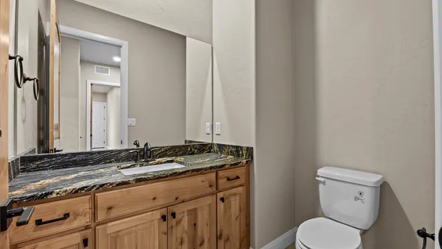 a kitchen with a granite countertop sink and cabinets