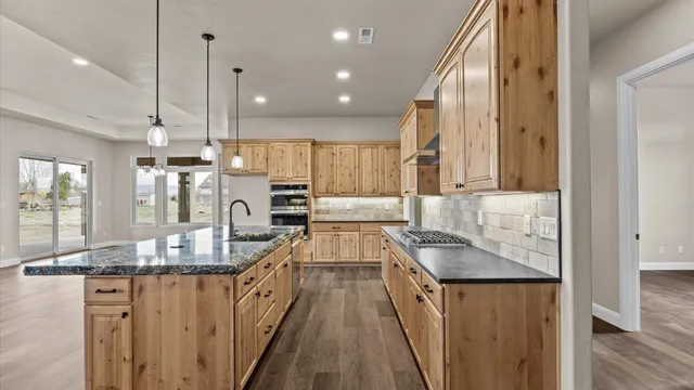 a kitchen with granite countertop kitchen island stainless steel appliances refrigerator stove microwave and cabinets