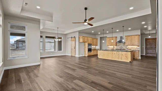 a large kitchen with white cabinets and wooden floor