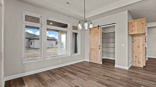 a view of empty room with wooden floor and window