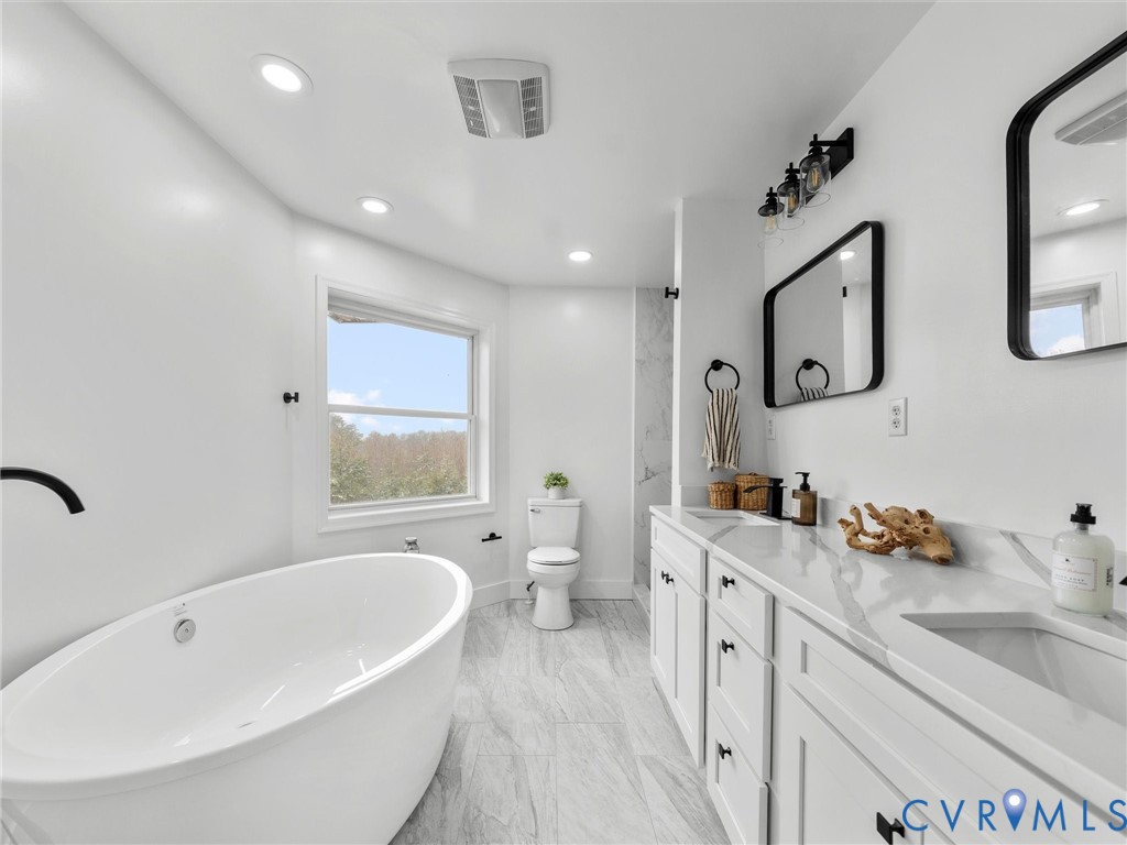 5117 Byrd Mill Road Louisa, VA 23093 - Photo 35 of 50 Bathroom with double vanity, a freestanding bath,
