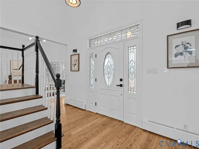 a view of a hallway with stairs and wooden floor