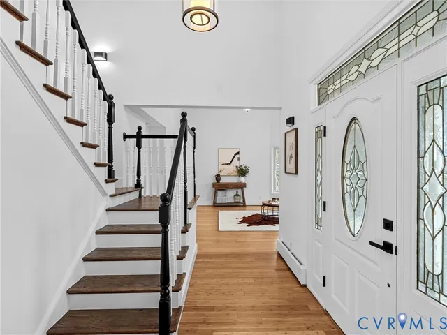 a view of staircase with lots of frames on wall and wooden floor