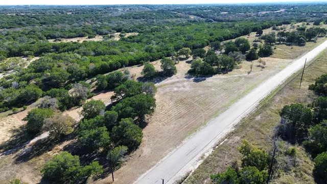 an aerial view of residential houses with outdoor space and trees