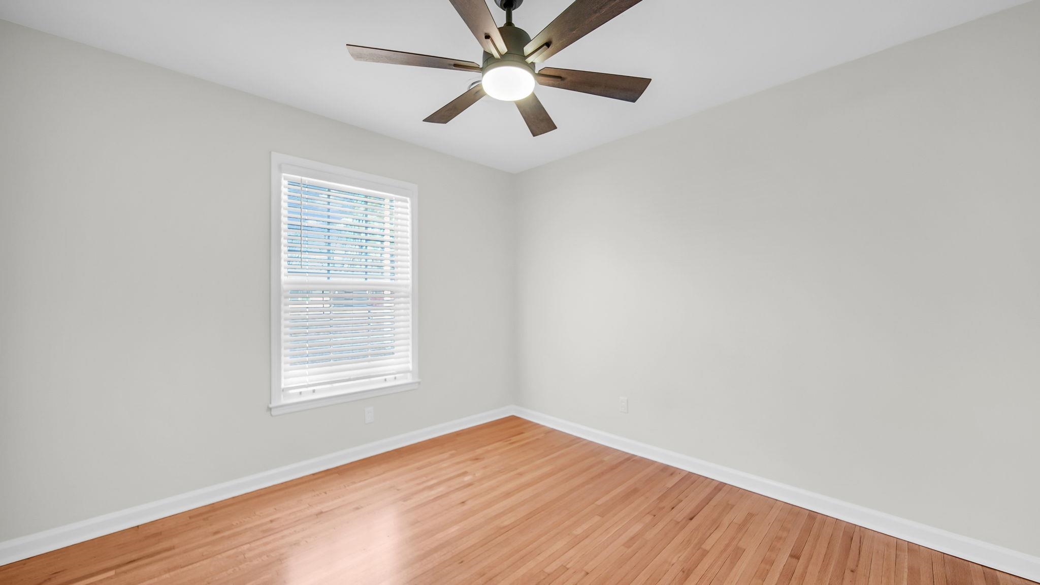 2800 Spring Hill Drive Memphis, TN 38127 - Photo 26 of 31 an empty room with wooden floor ceiling fan and windows