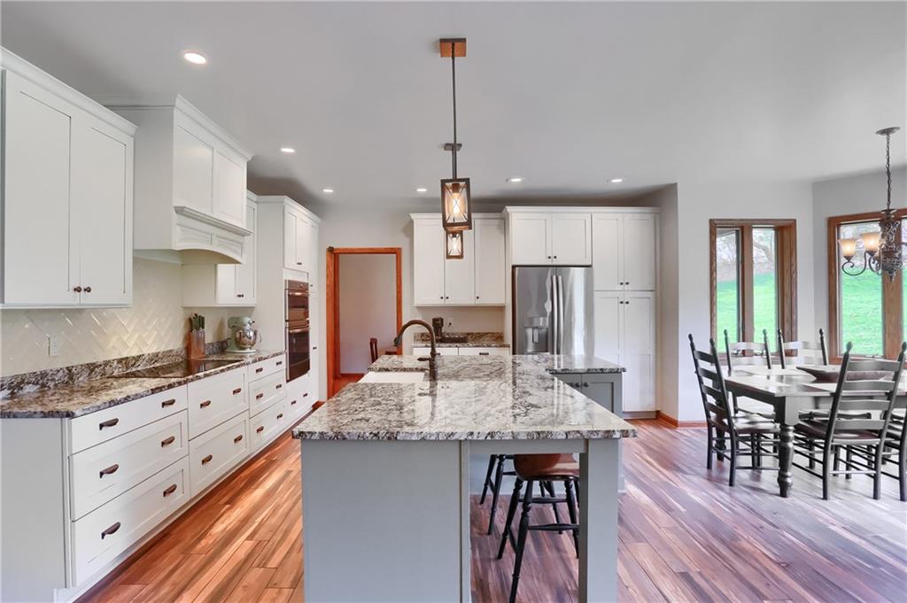 110 Larkspur Circle Butler, PA 16002 - Photo 14 of 50 Pendant lighting glistens on the counters of the expansive island with casual seating, storage, a large eat in dining area encased with windows and access to the rear patio.