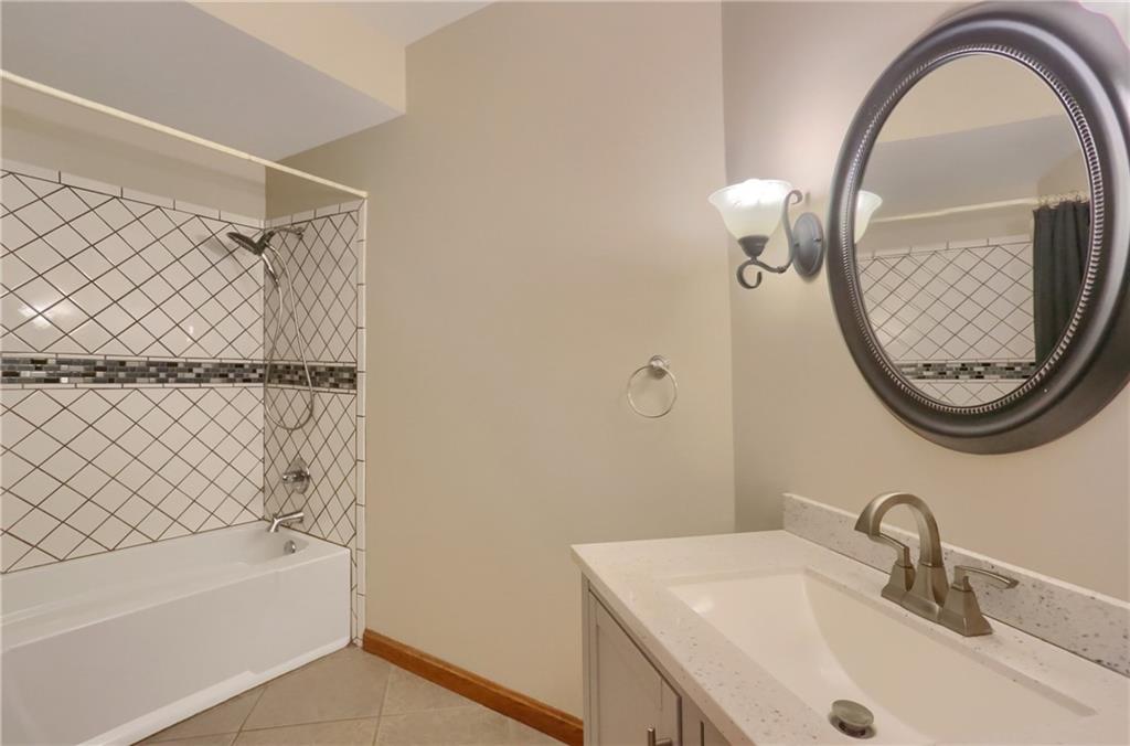 110 Larkspur Circle Butler, PA 16002 - Photo 23 of 50 A main level full bathroom features a tiled tub/shower combo, tile flooring and a modern vanity.