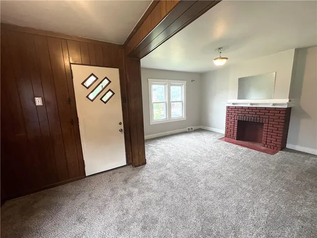 an empty room with windows and fireplace