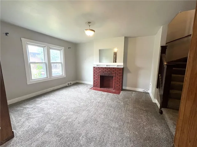 an empty room with fireplace and windows
