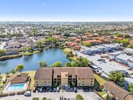 an aerial view of residential houses with outdoor space and lake view