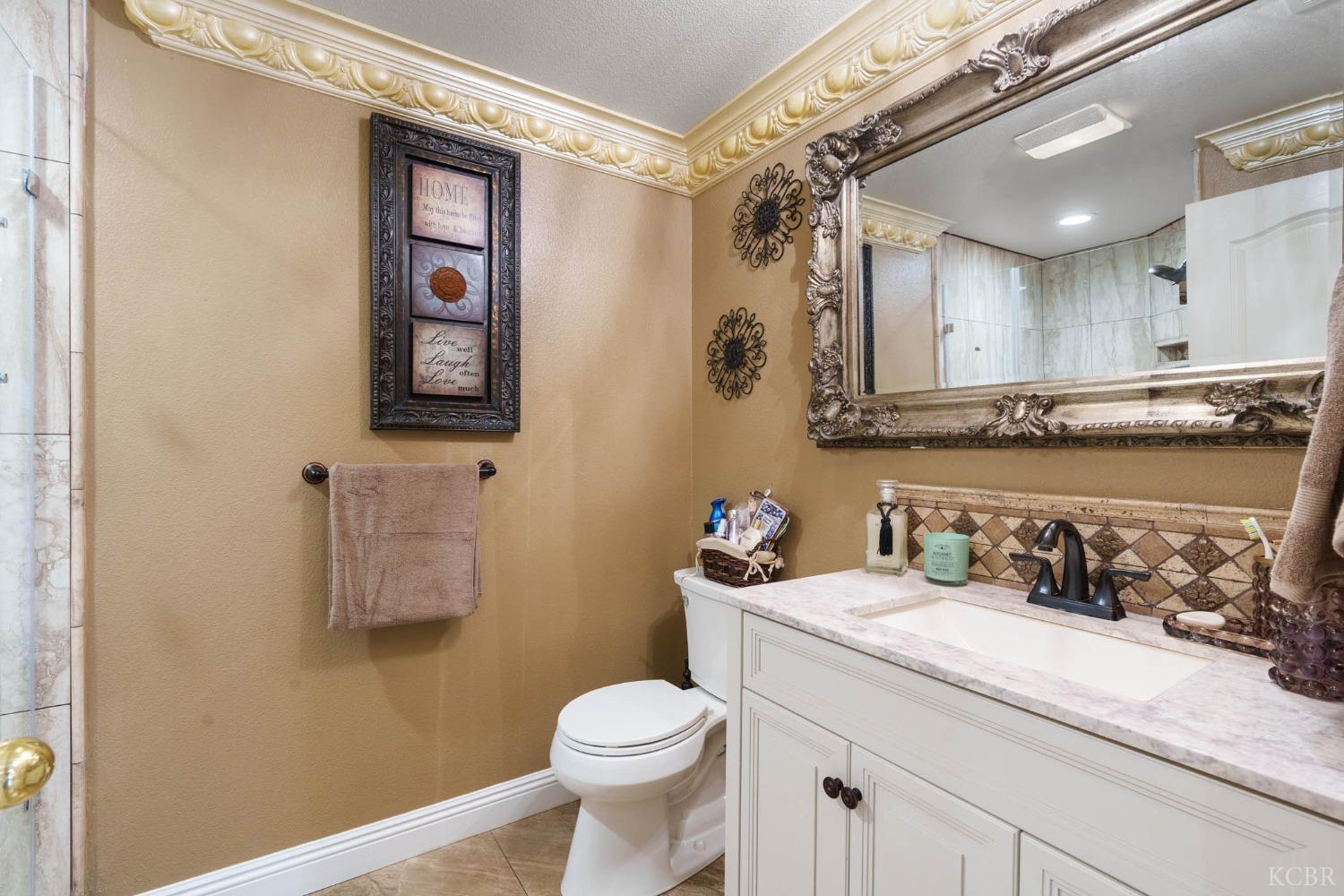 960 Vista Place Lemoore, CA 93245 - Photo 11 of 34 a bathroom with a toilet sink and mirror