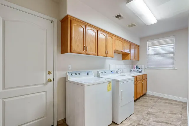 a utility room with cabinets washer and dryer