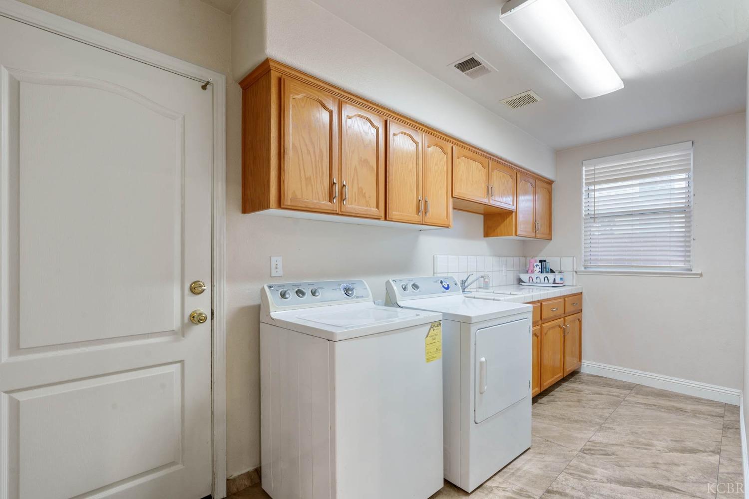 960 Vista Place Lemoore, CA 93245 - Photo 12 of 34 a utility room with cabinets washer and dryer