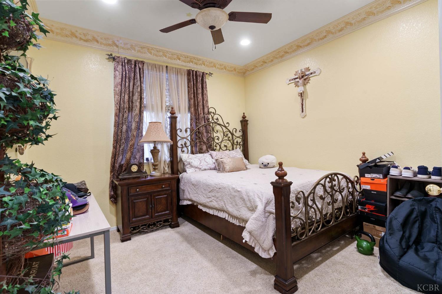 960 Vista Place Lemoore, CA 93245 - Photo 13 of 34 a bed room with a bed and a chandelier
