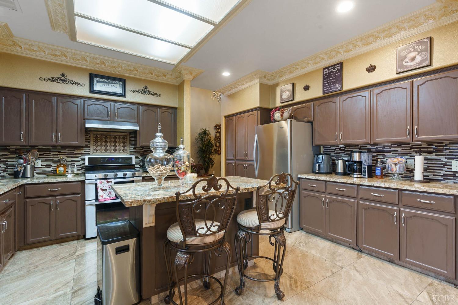 960 Vista Place Lemoore, CA 93245 - Photo 15 of 34 a kitchen with a table chairs refrigerator and cabinets