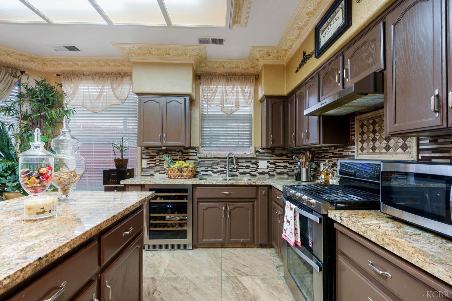 960 Vista Place Lemoore, CA 93245 - Photo 17 of 34 a kitchen with a sink stove and cabinets