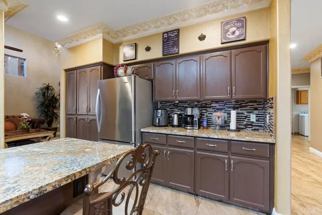 a kitchen with stainless steel appliances granite countertop a refrigerator and a stove