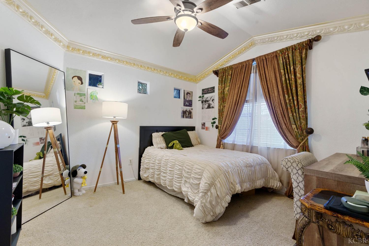 960 Vista Place Lemoore, CA 93245 - Photo 24 of 34 a bedroom with a bed and a chandelier