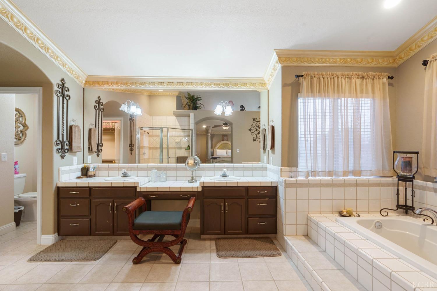 960 Vista Place Lemoore, CA 93245 - Photo 26 of 34 a large bathroom with a double vanity sink large mirror and a bathtub