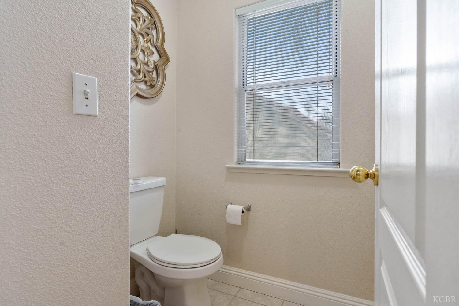 960 Vista Place Lemoore, CA 93245 - Photo 29 of 34 a bathroom with a toilet and a window