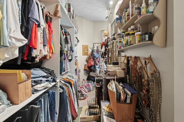 a view of walk in closet with clothes and shoes