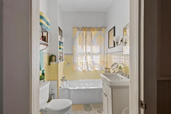 a bathroom with a granite countertop sink a toilet and shower curtain