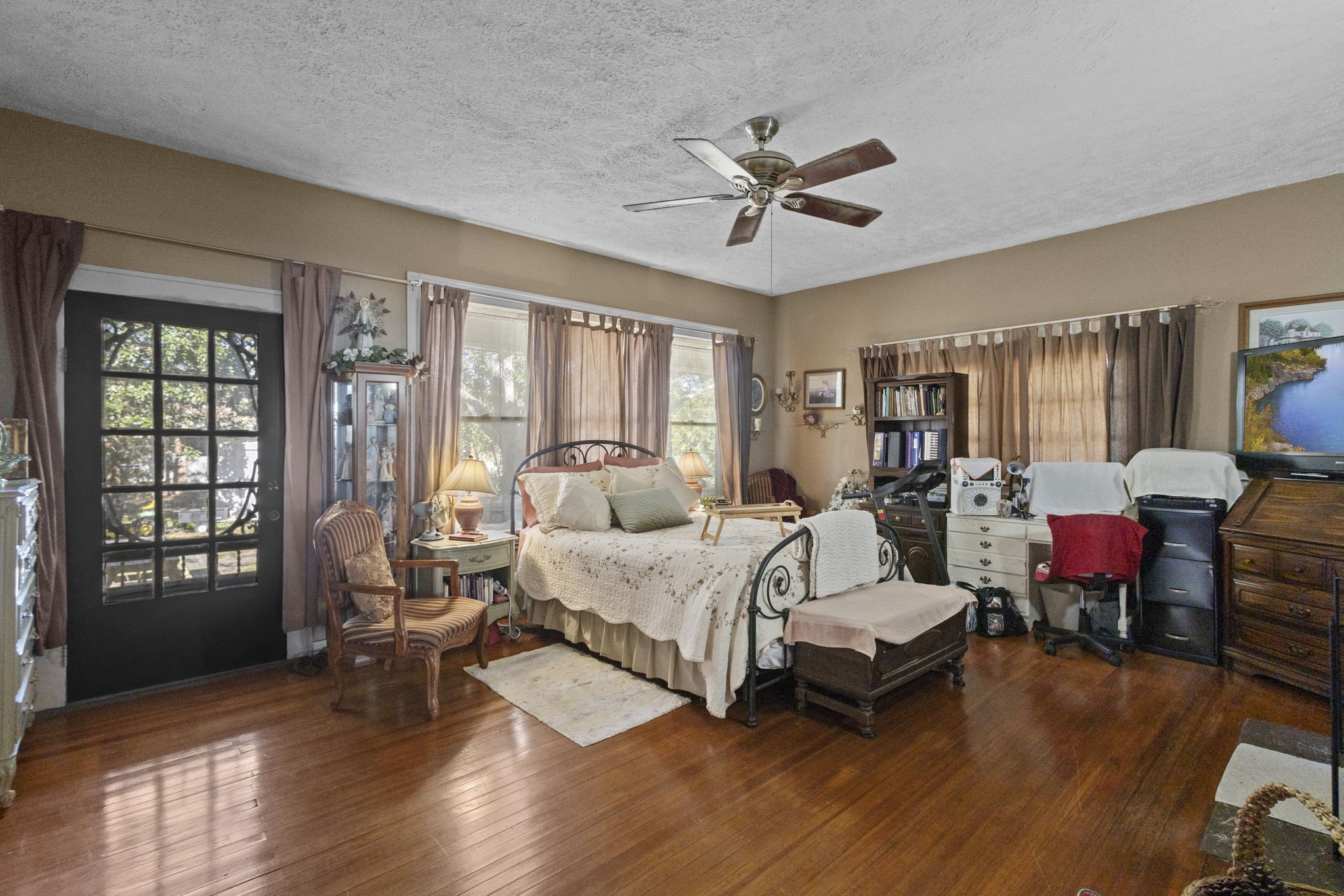 105 Mann Street Colmesneil, TX 75938 - Photo 5 of 40 a spacious bedroom with a bed a couch and large window